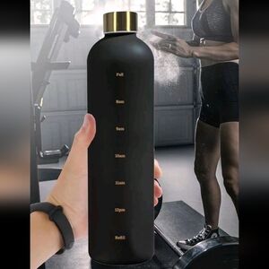 Black water bottle with recommended daily consumption times on the side